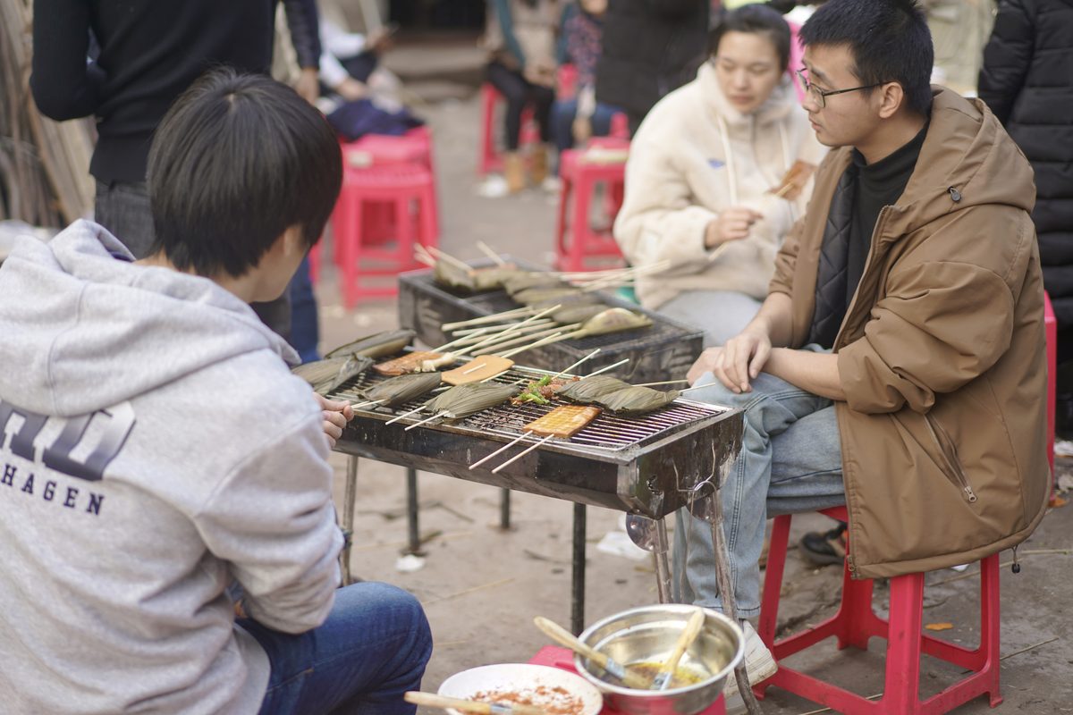 青年围坐户外烧烤吃串