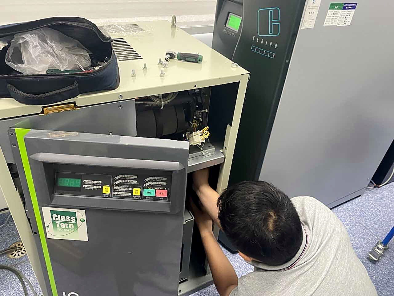 实验室仪器现场检修,机身贴有 Class Zero 认证标识,工作人员拆开侧板检修内部