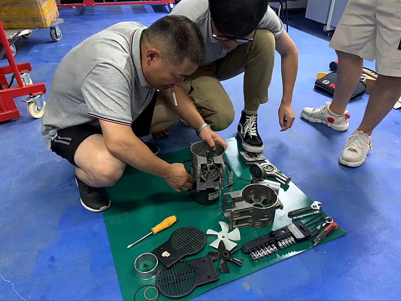 活动现场拆解仪器部件教学,摊主在防静电垫上拆机并向围观同行讲解